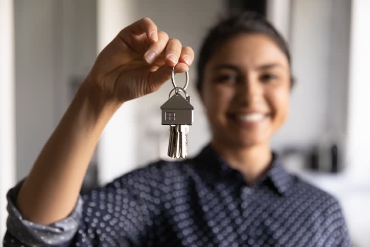 tenant holding keys in her hand smiling because she now has renters insurance